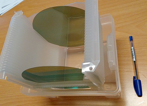 Zwei ∅150-mm-Siliciumcarbid-Wafer, im sichtbaren Bereich des Lichts teilweise transparent
